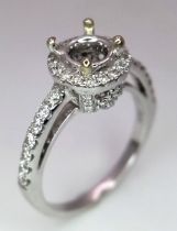 AN 18K WHITE GOLD DIAMOND HALO SOLITAIRE RING MOUNT WITH DIAMOND SET SHOULDERS. Ready to set your