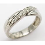 A 9K white Gold (tested) Diamond Twist Ring. 0.05ct diamond. Size K. 2.4g total weight.