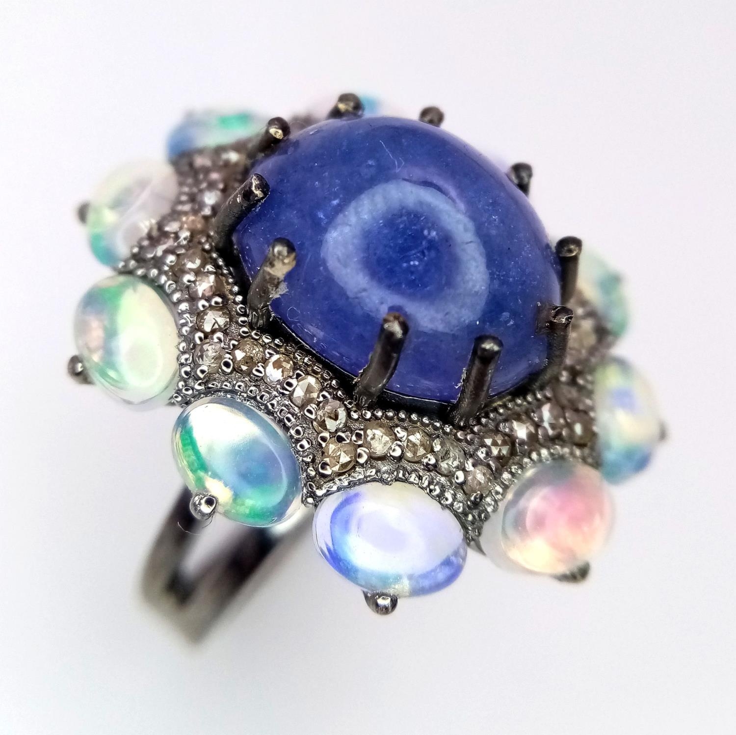 A 10ct Tanzanite Gemstone Dress Ring with 3ctw Opal Surround and 0.50ctw of Diamond Accents. Size N.