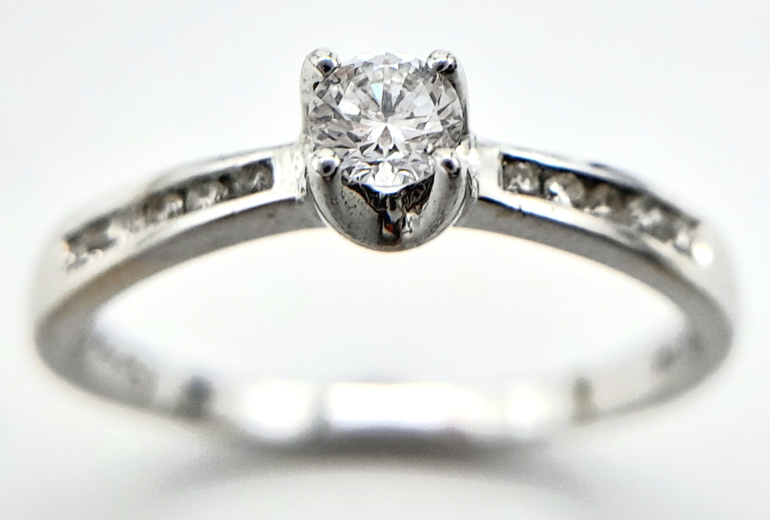AN 18K WHITE GOLD DIAMOND SOLITAIRE RING - WITH DIAMOND SHOULDERS. 0.25CT. 1.9G. SIZE L - Image 3 of 6