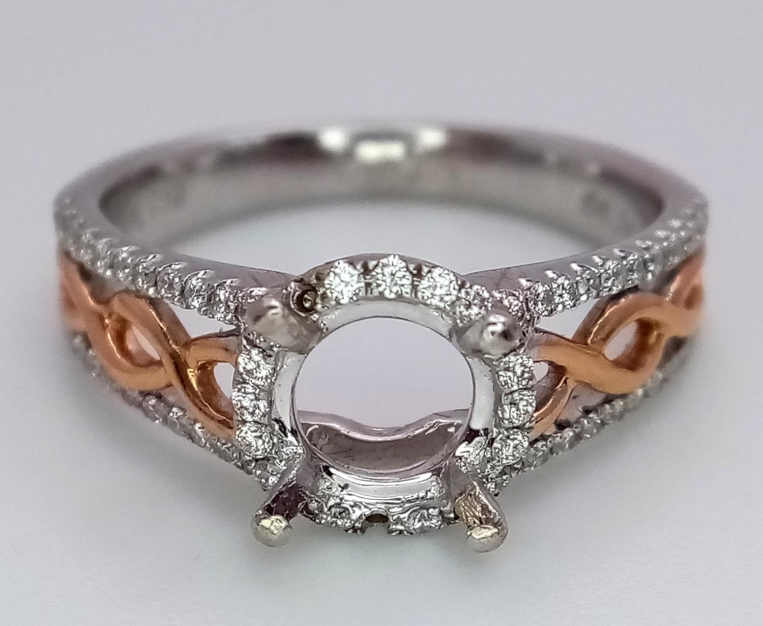 A 18K TWO GOLD TONE DIAMOND SET HALO RING WITH DIAMOND SPLIT SHOULDERS. 0.26CT DIAMONDS. READY TO