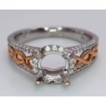 A 18K TWO GOLD TONE DIAMOND SET HALO RING WITH DIAMOND SPLIT SHOULDERS. 0.26CT DIAMONDS. READY TO