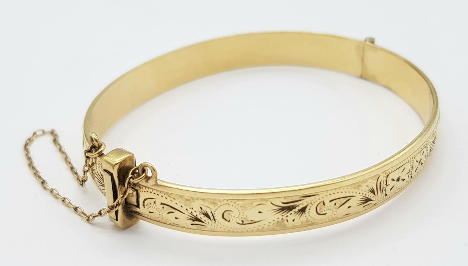 A 9K YELLOW GOLD AND METAL CORE ENGARVED BANGLE 18.3G , 53mm x 60mm diameter. ref: ADAM 9001