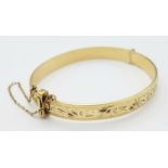 A 9K YELLOW GOLD AND METAL CORE ENGARVED BANGLE 18.3G , 53mm x 60mm diameter. ref: ADAM 9001