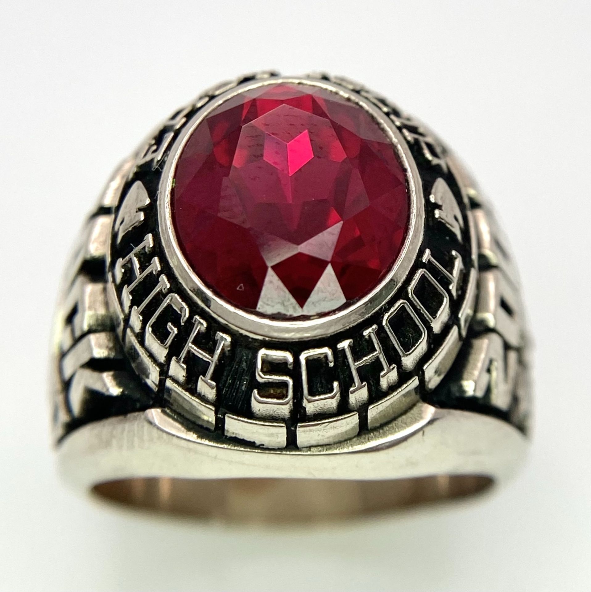 A 10K White Gold and Ruby Gents High School Ring. Size P 1/2. 18g total weight. Ref: 17043