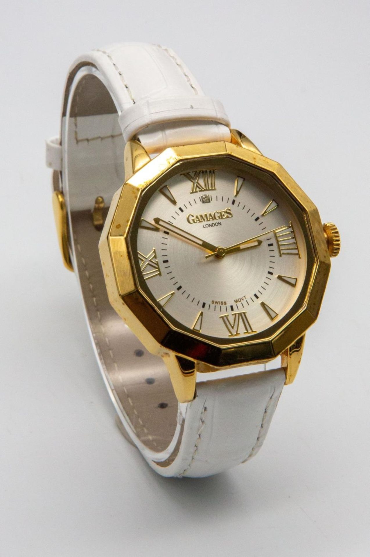 A Gamages of London Quartz Ladies Watch. White leather strap. Gilded case - 38mm. Silver tone