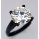 A 4ct Moissanite Solitaire Ring. Set in a matt black finish metal. Comes with a GRA certificate.