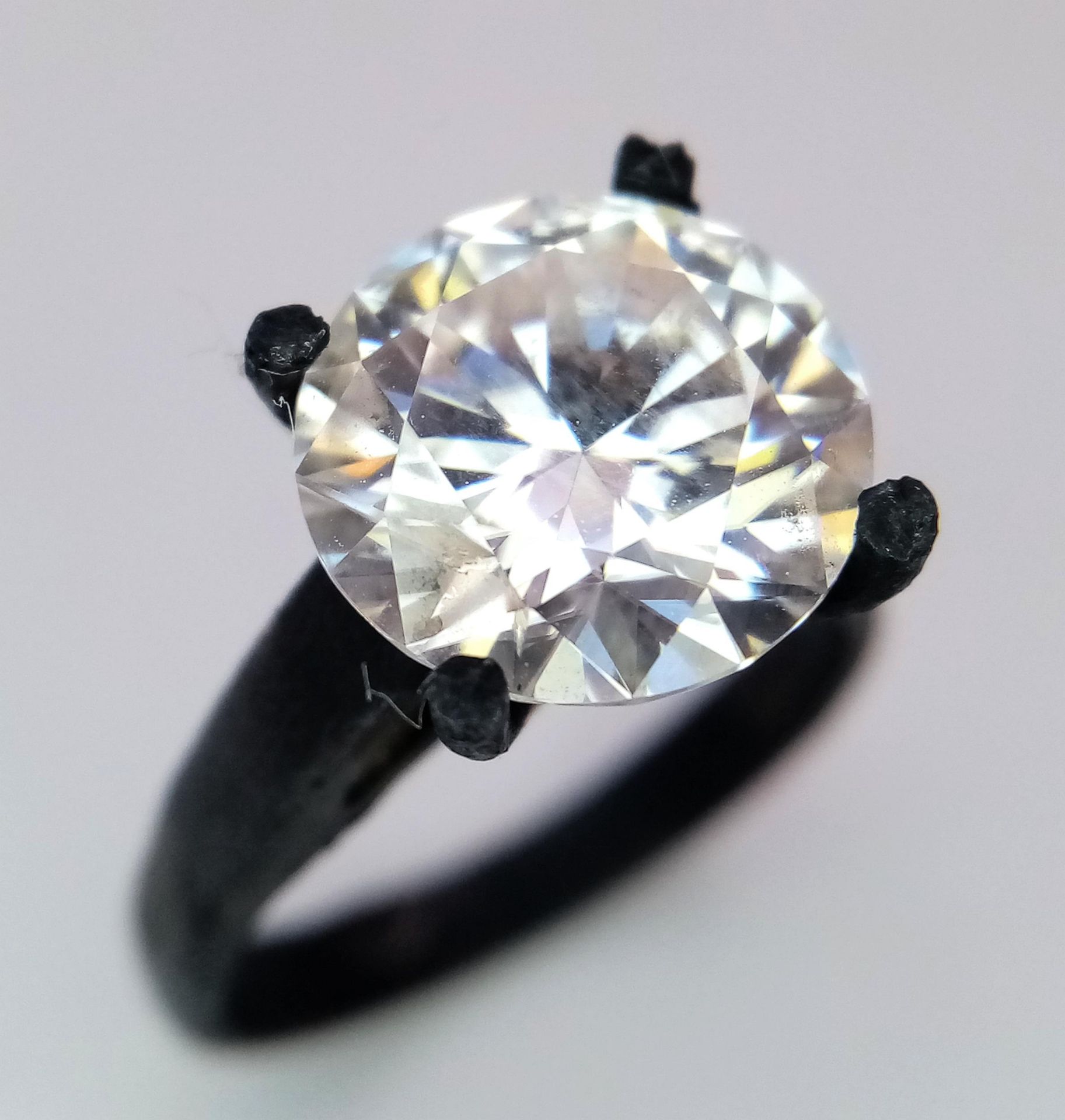 A 4ct Moissanite Solitaire Ring. Set in a matt black finish metal. Comes with a GRA certificate.