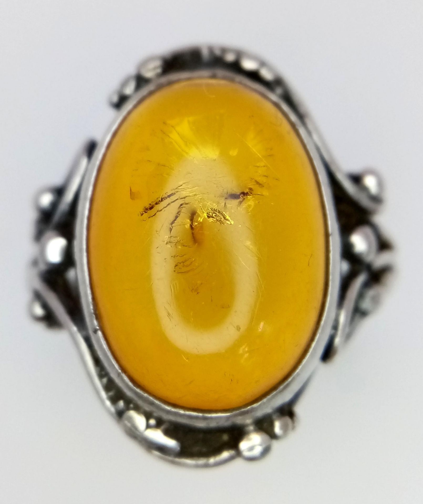 A Vintage or Antique, Ornate Mounted, Silver Amber Cabochon Ring Size S. Set with a 1.8cm Long Amber - Image 3 of 5