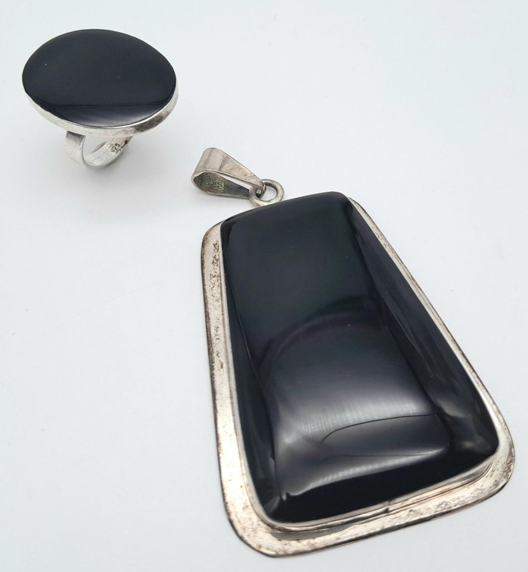 A Mexican silver and black onyx pendant (83mm x 46mm) and ring (size L) total weight 60.4g. ref: