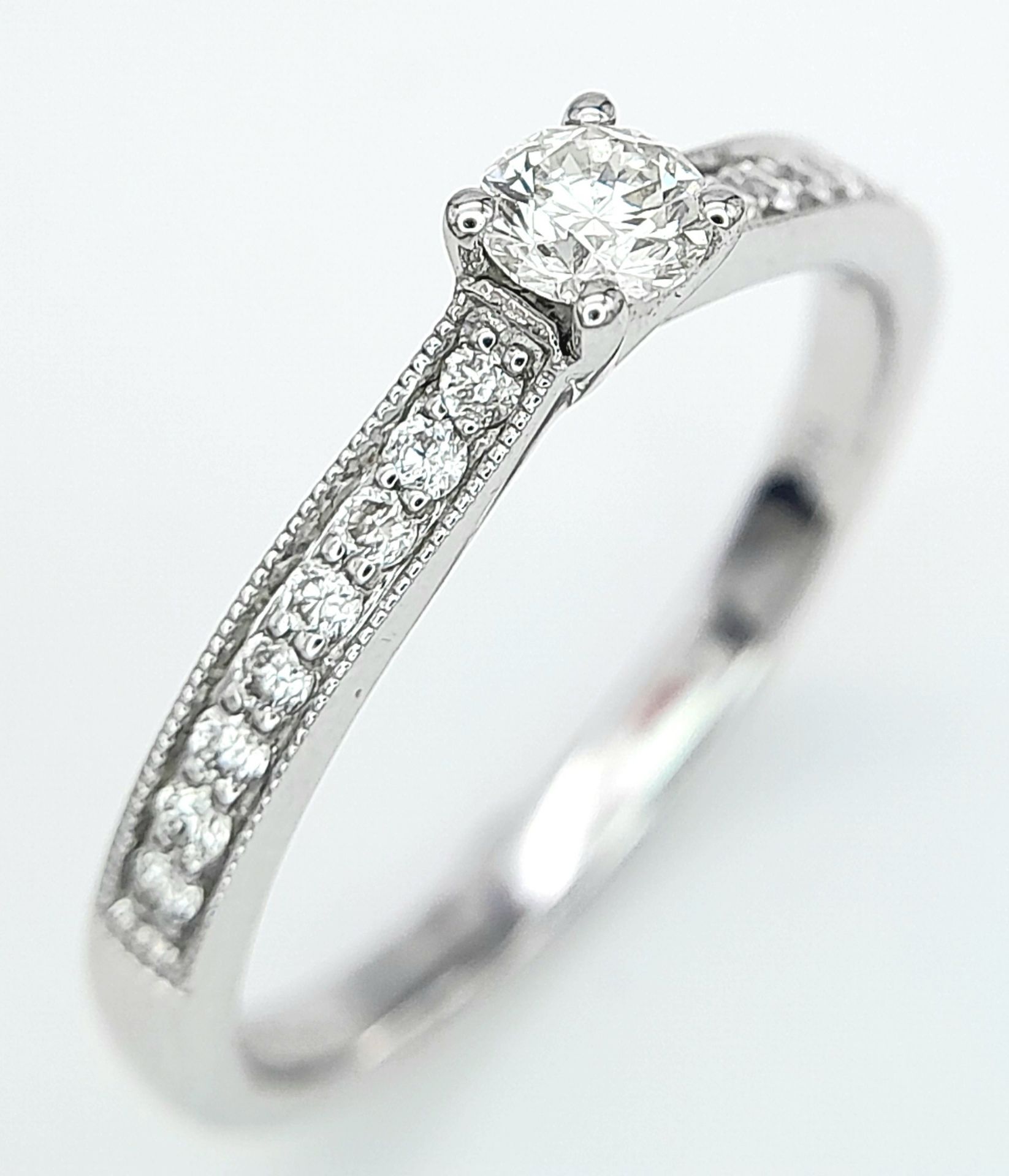 AN 18K WHITE GOLD DIAMOND SOLITAIRE RING - WITH DIAMOND SET SHOULDERS. 0.35CT. TOTAL 2.6G. SIZE N - Image 3 of 5