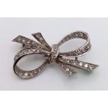 An Art Deco Style Platinum and Diamond Brooch. 1.2ctw of encrusted diamonds in a bow form. 4cm. 5.7g