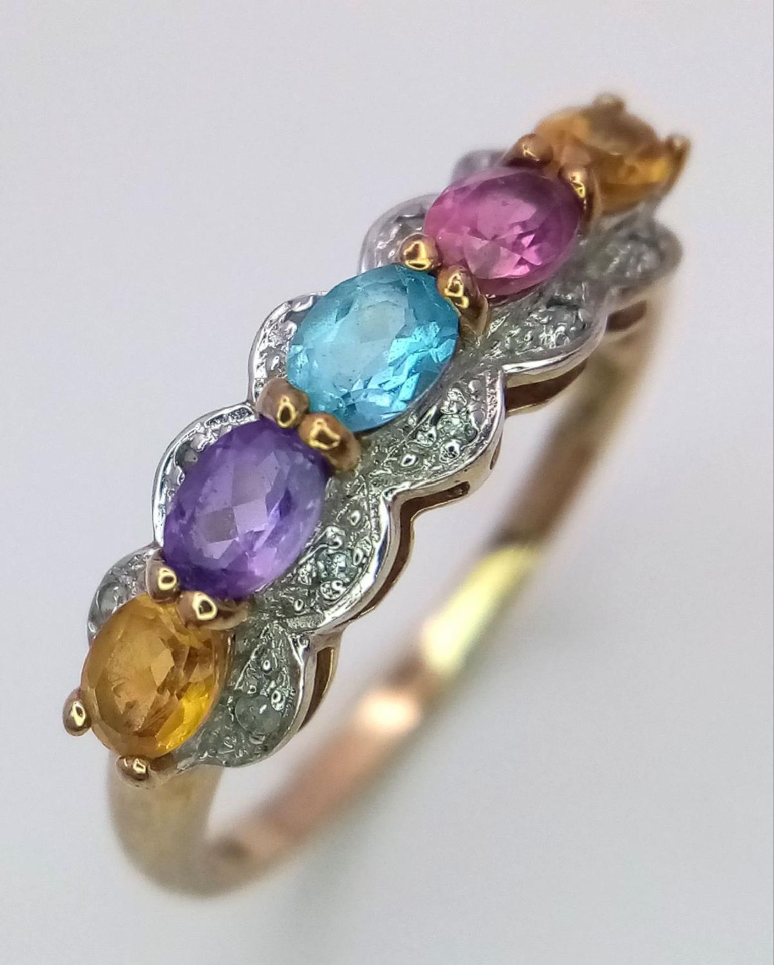 A 9ct yellow gold multi stone ring, featuring diamonds, amethyst, citrine and topaz, size P, 2g.