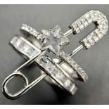 A very fashionable, designer style, white metal (untested) ring with a safety pin and numerous cubic