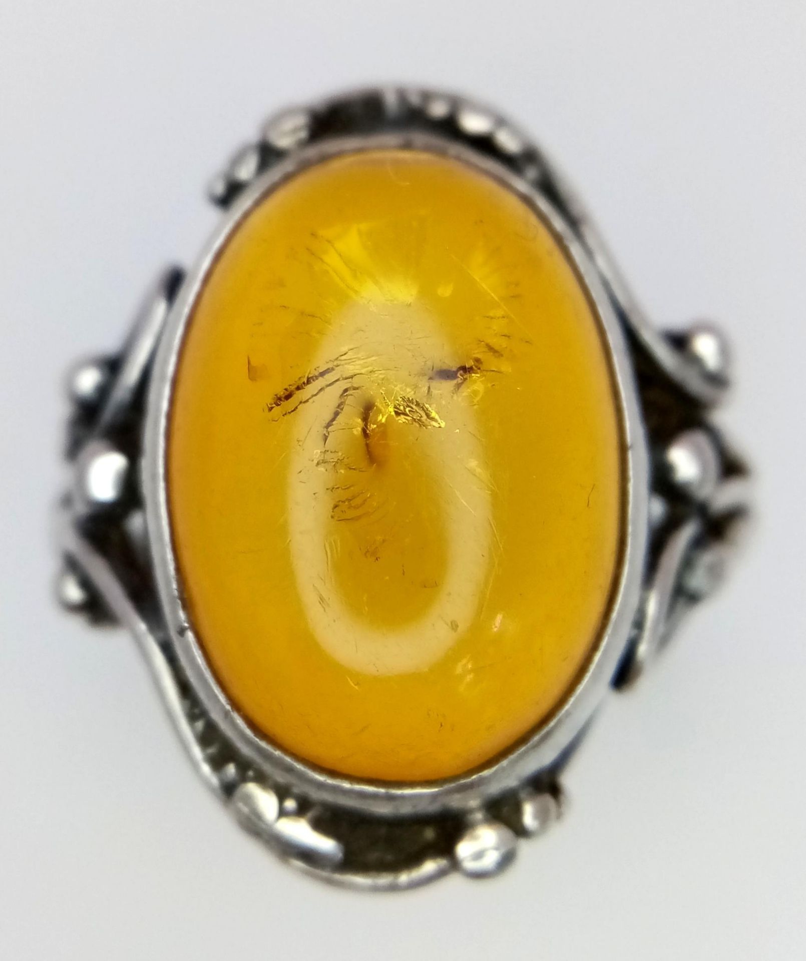 A Vintage or Antique, Ornate Mounted, Silver Amber Cabochon Ring Size S. Set with a 1.8cm Long Amber - Image 2 of 5