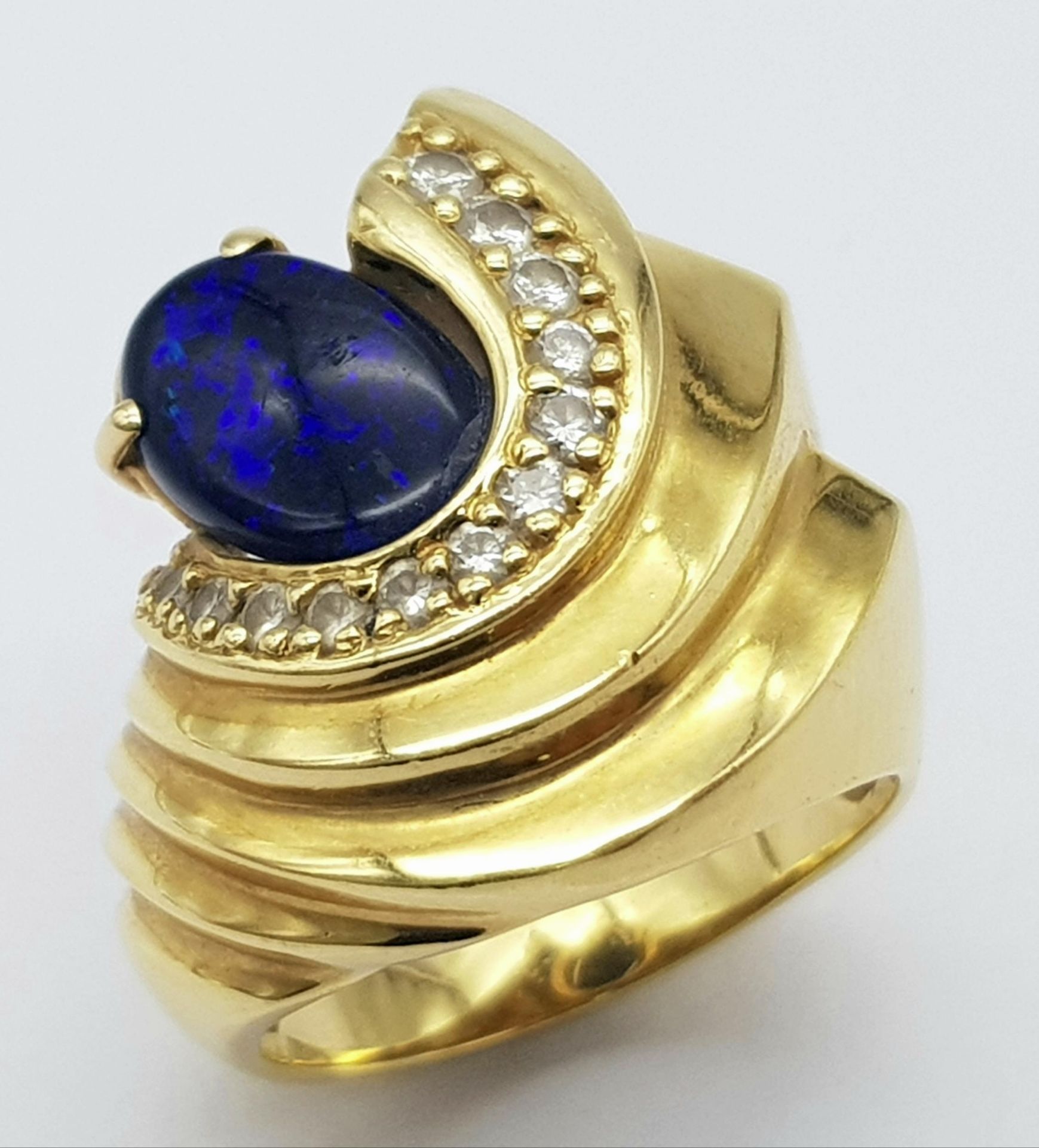 A Gorgeous 18K Yellow Gold (tested) Australian Black Opal and Diamond Ring. An enticing oval cut