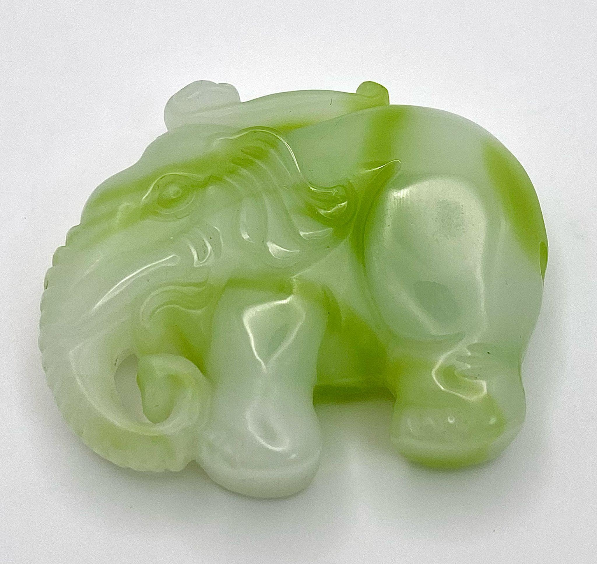 A Chinese Green and White Jade Elephant Figurine Pendant. 5cm x 4cm.