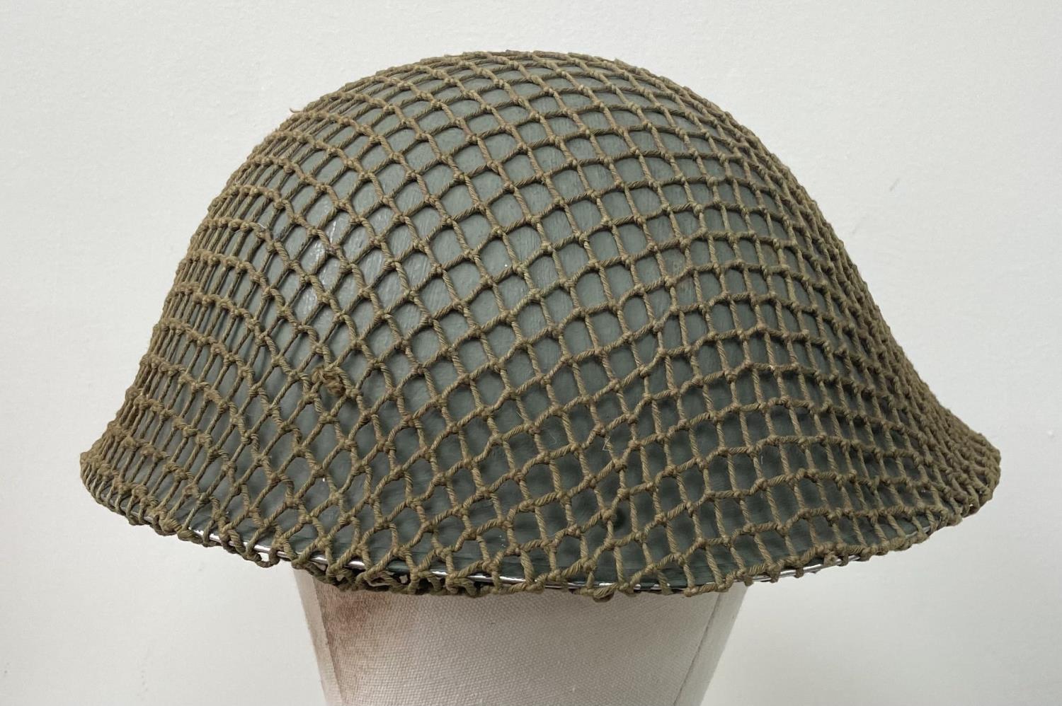 A British Army Mark V steel helmet, complete with camouflage net. Very good condition - Bild 3 aus 4