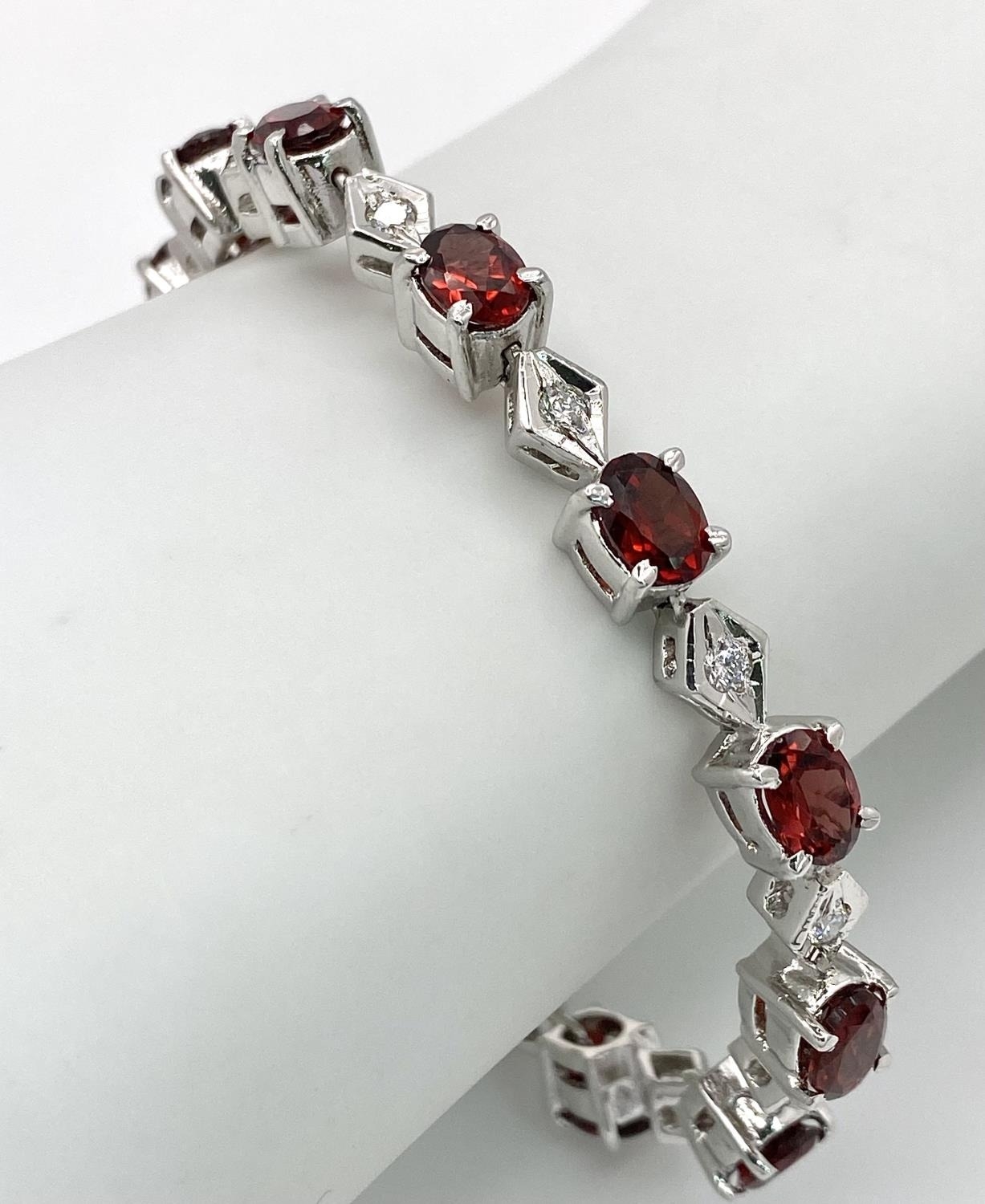 A Garnet and White Zircon Tennis Bracelet set in 925 Sterling silver. 32ctw. W-23.80g. Ref: HV2159 - Image 3 of 4