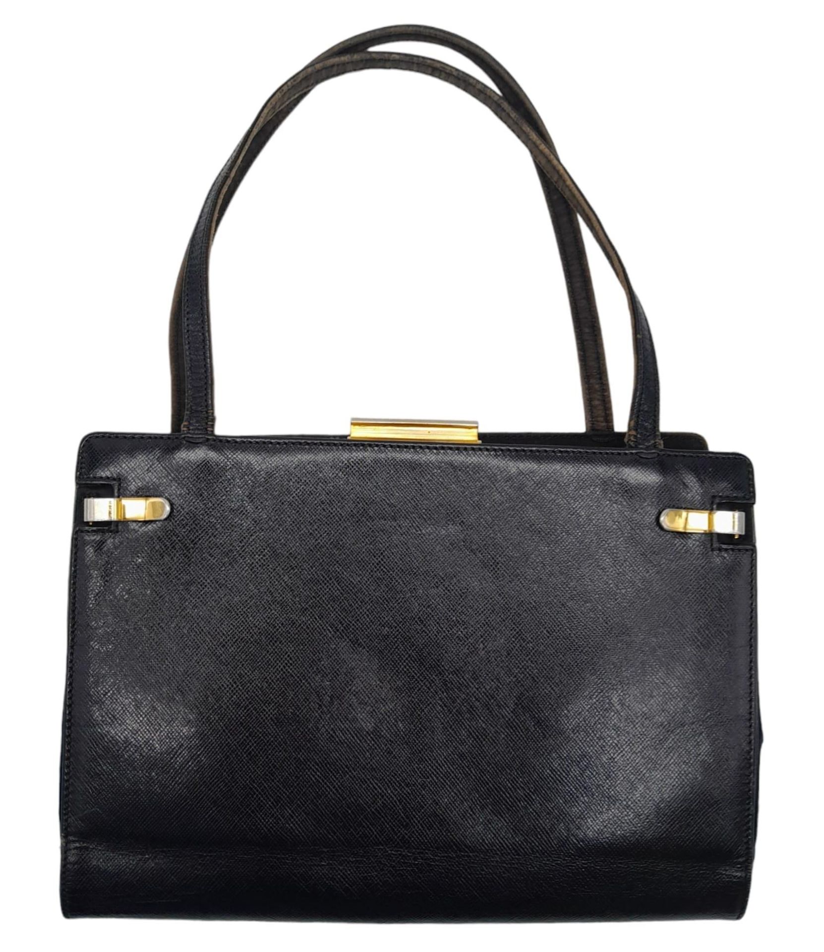A Gucci Black Hand Bag. Leather exterior with gold-toned hardware, two thin straps, and clasp