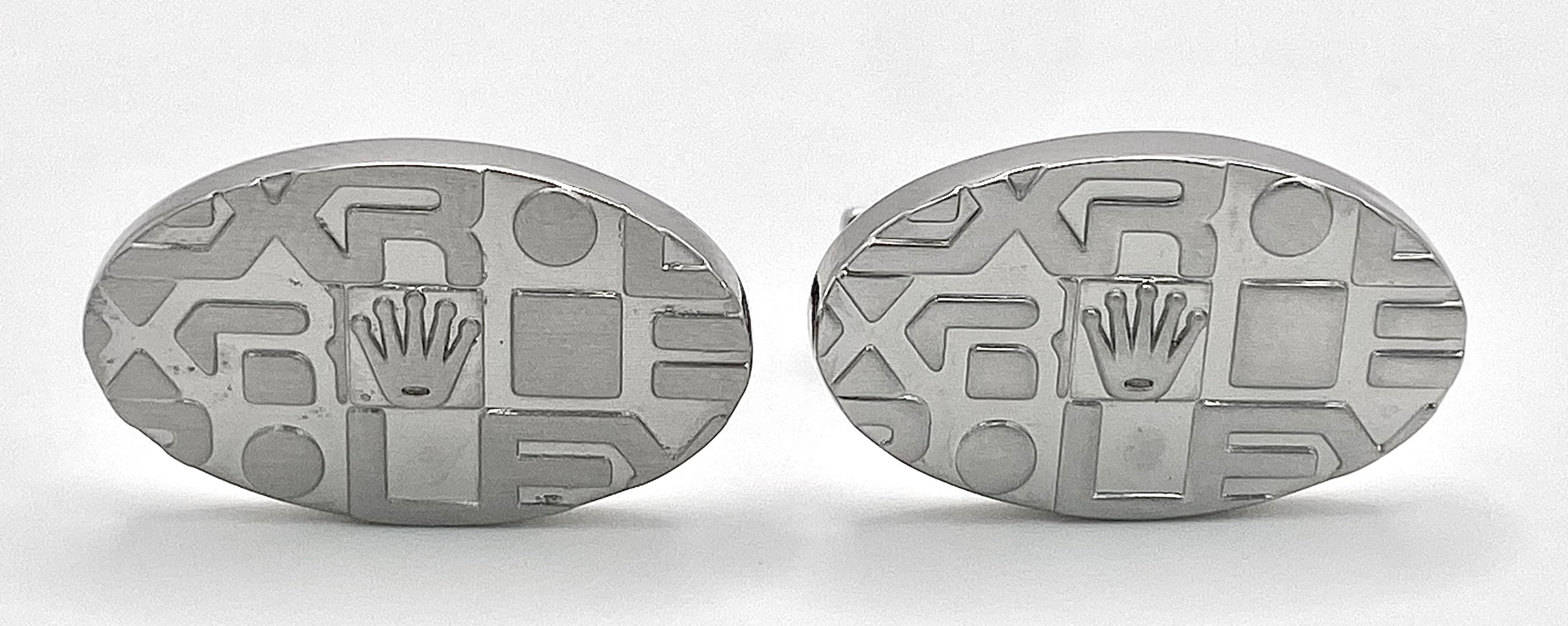 A white metal pair of modern ROLEX cufflinks, in a presentation box (not Rolex). We understand,