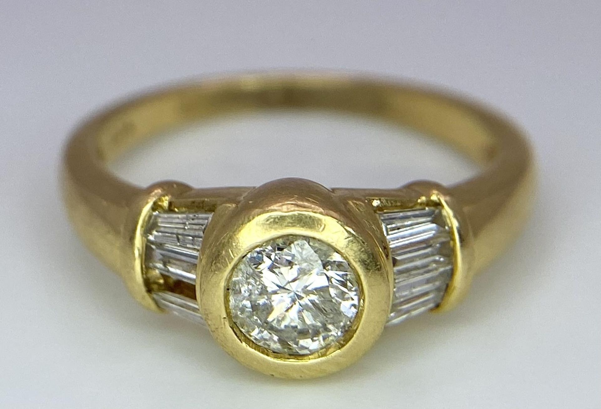 A 9 K yellow gold ring with a round cut diamond and more baguette diamonds on shoulders (one - Image 4 of 6