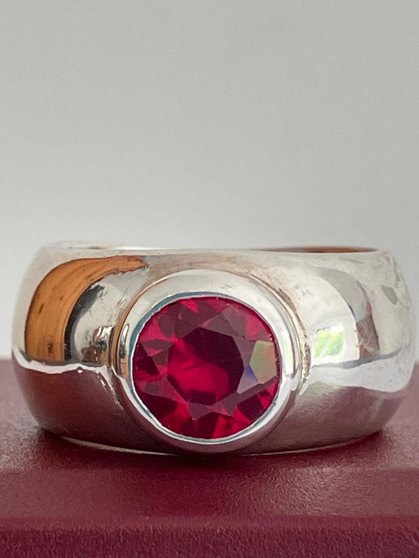 SILVER and RUBY RING, consisting a 1.5 carat Round Cut Ruby mounted to top of a Wide Silver Band.