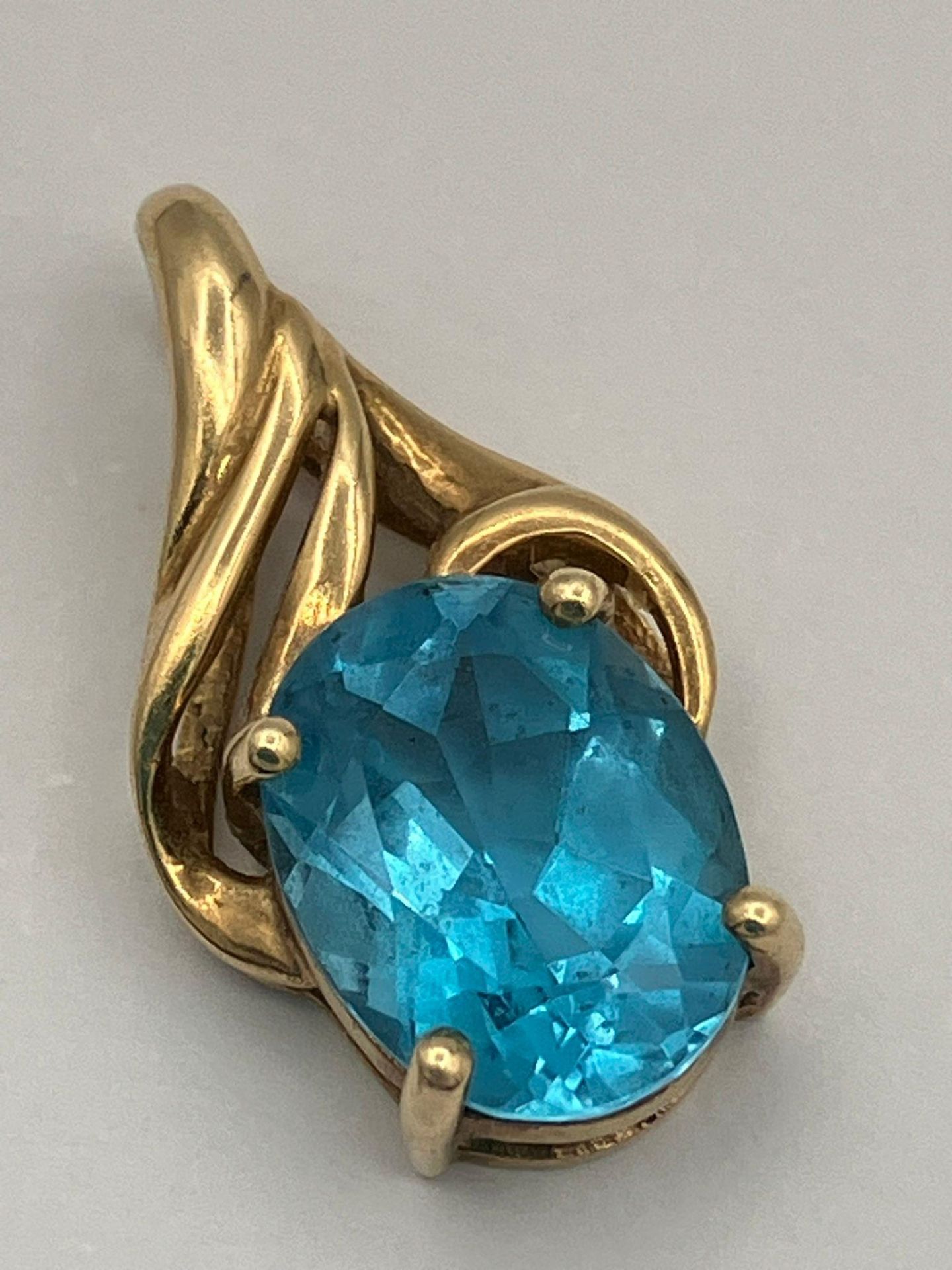 9 carat GOLD and TOPAZ PENDANT. Having a 1.5 carat OCEAN BLUE TOPAZ ,Oval Cut and set in a four claw