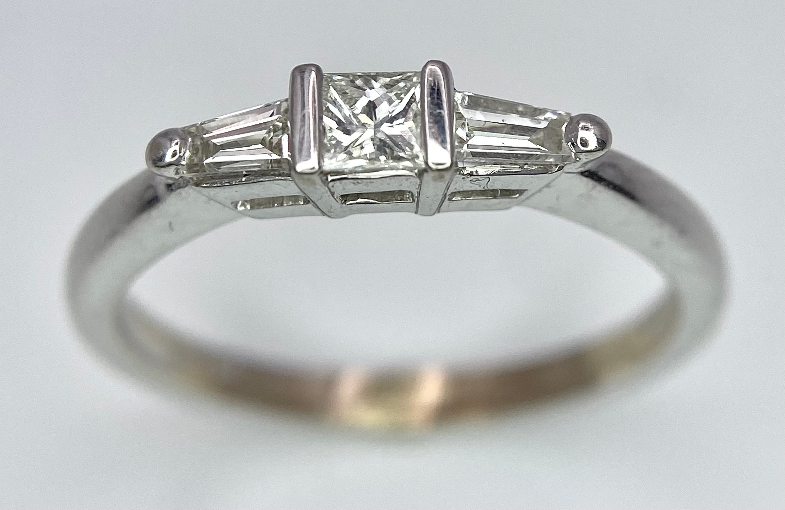 AN 18K WHITE GOLD, DIAMOND 3 STONE RING - PRINCESS CUT CENTRE WITH A TAPPERED BAGUETTE DIAMOND - Image 2 of 7