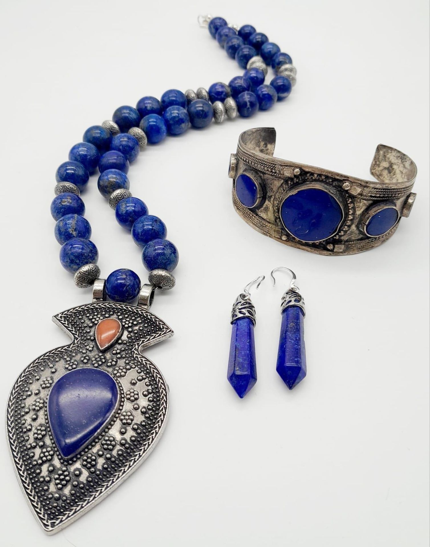 A Lapis Lazuli Jewellery Suite: Cuff bangle, necklace and earrings. 48cm length.