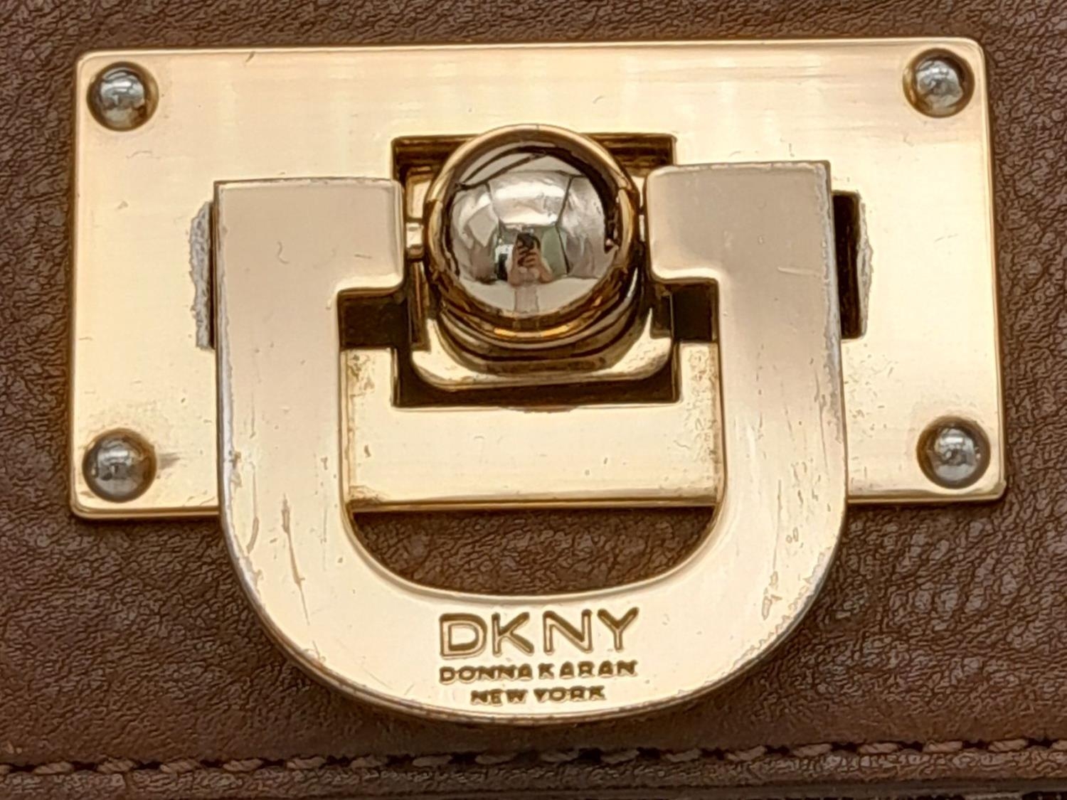 A DKNY Brown Satchel Bag. Canvas and leather exterior with gold-toned hardware, four protective base - Image 5 of 10