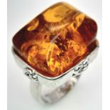An Amber on White Metal Ring. Size S/T, 12g total weight.