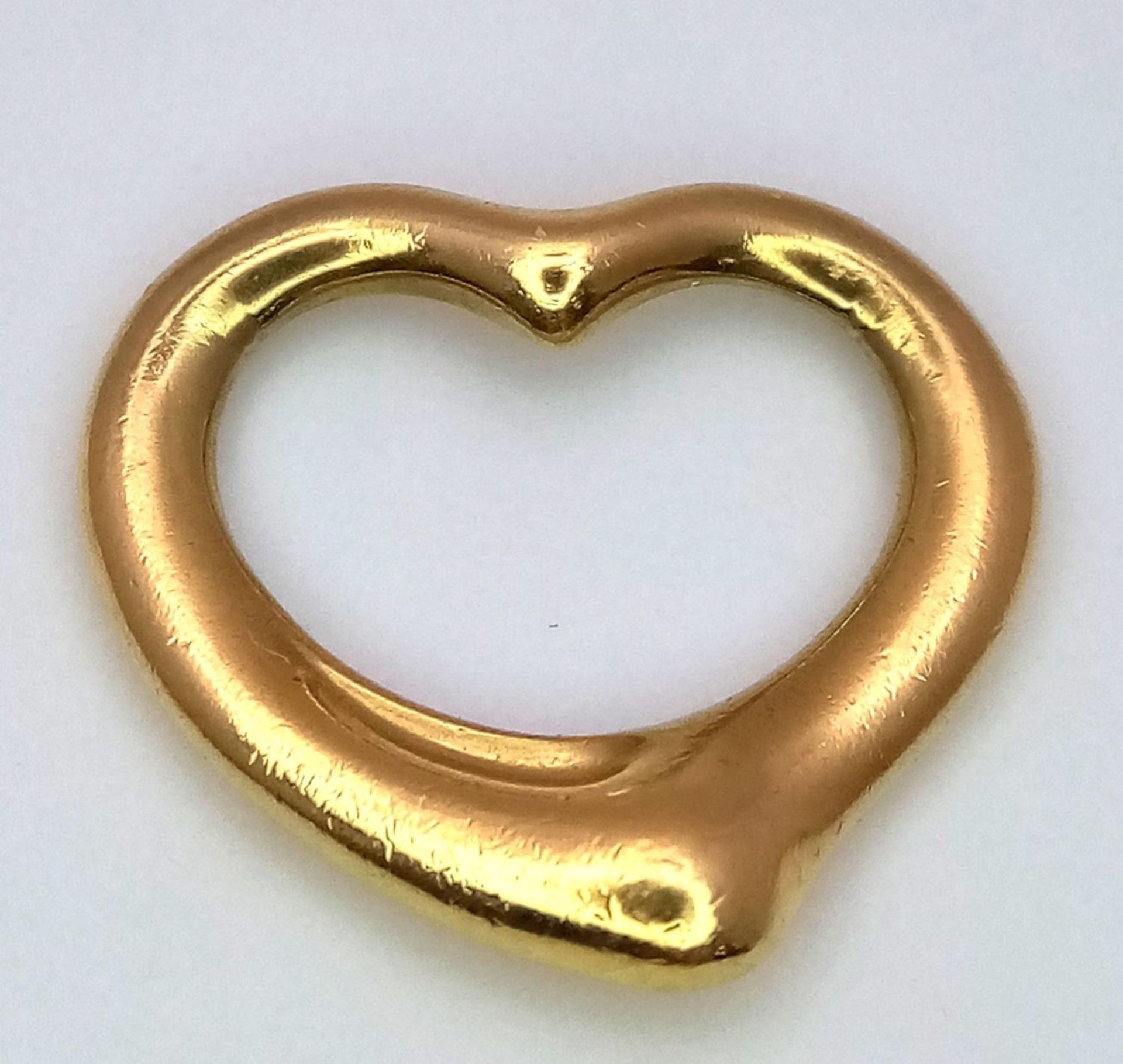 A Tiffany and Co. 18K Yellow Gold Heart Pendant. Tiffany markings. 15 x 15mm. 2g