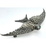 A Vintage Silver and Marcasite Brooch of a Bird in Flight. 7cm wingspan. Green stone eyes.