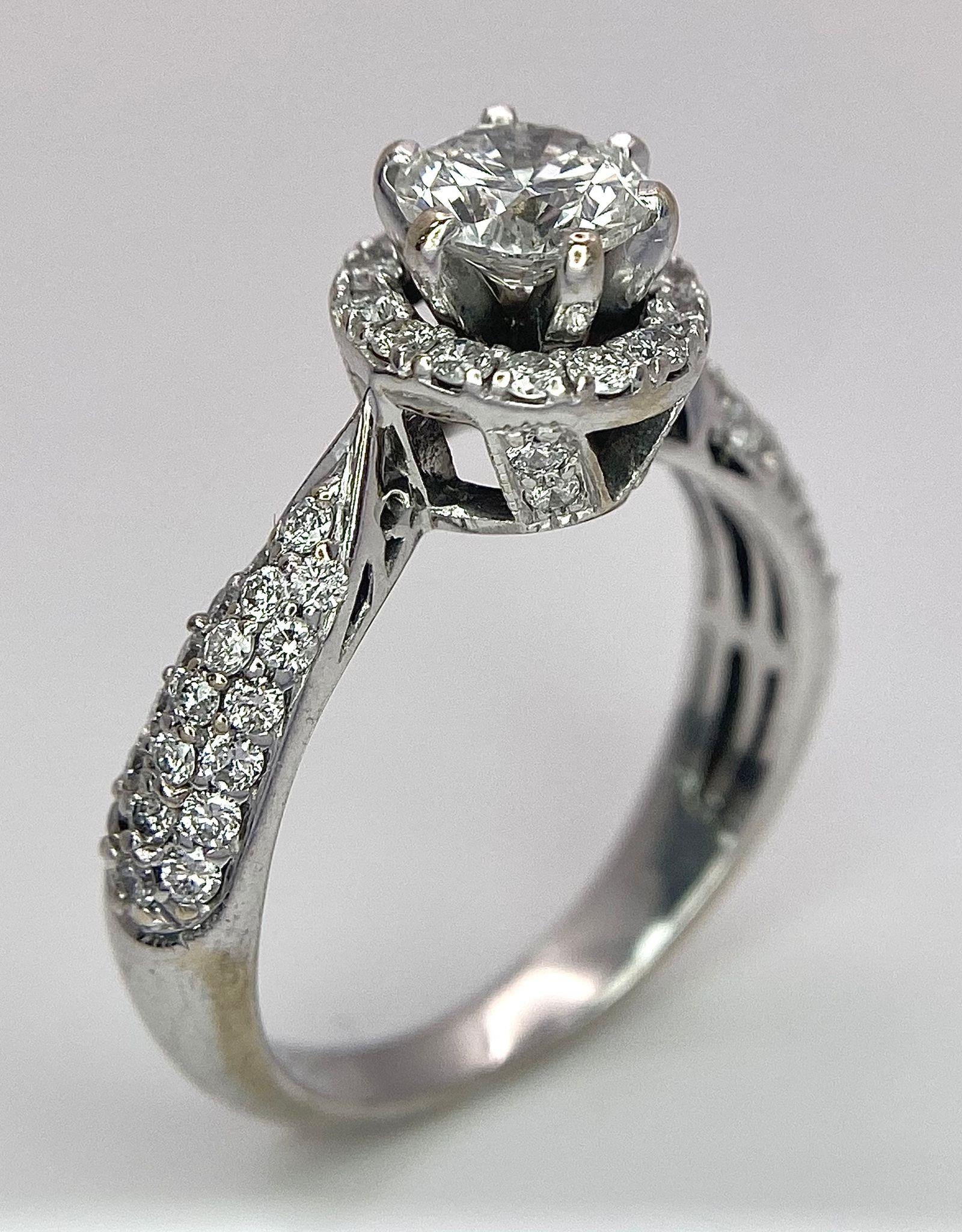 An 18K White Gold Diamond Ring. Central 0.75ct brilliant round cut diamond with a diamond halo and - Image 6 of 10