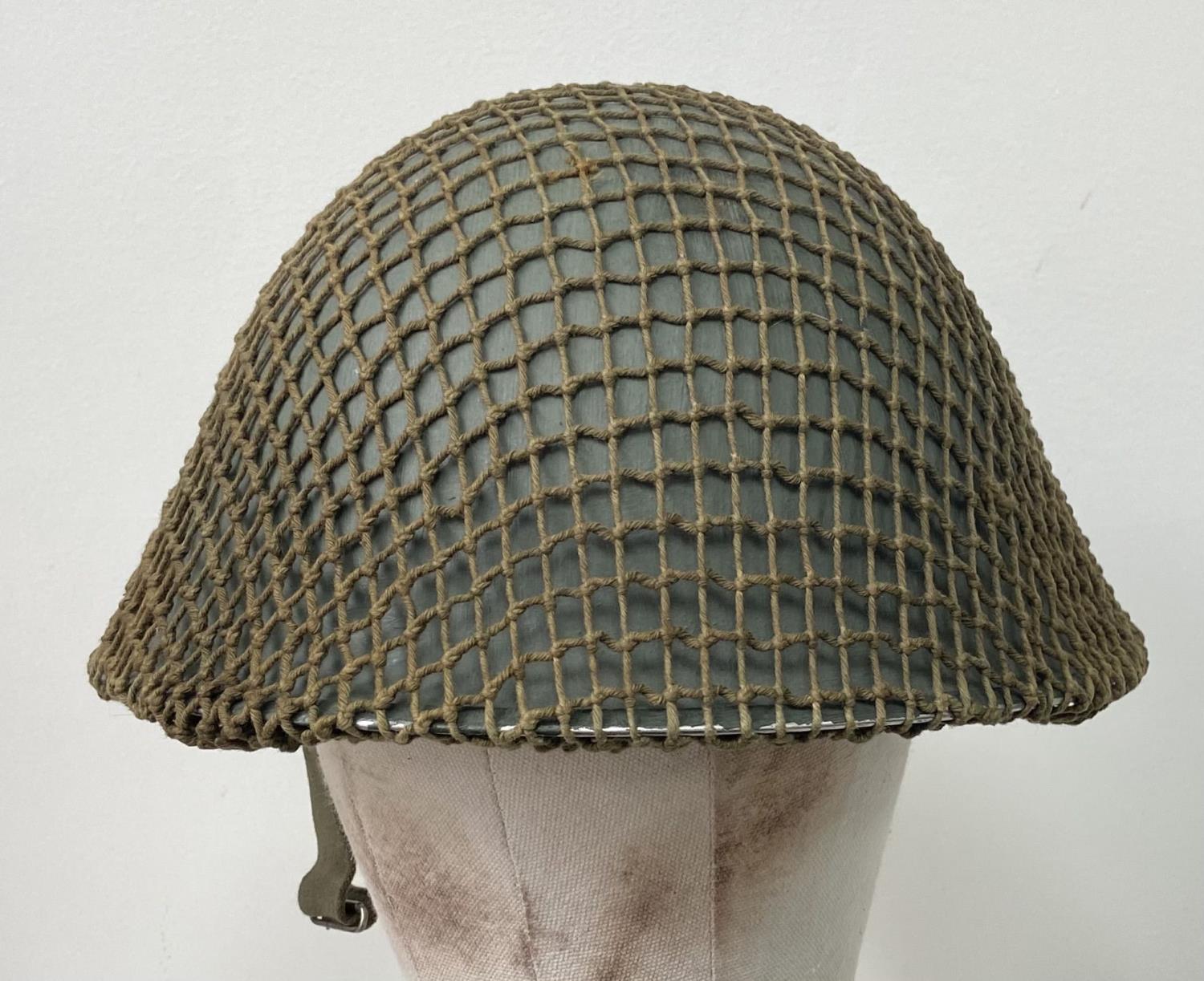 A British Army Mark V steel helmet, complete with camouflage net. Very good condition - Bild 2 aus 4