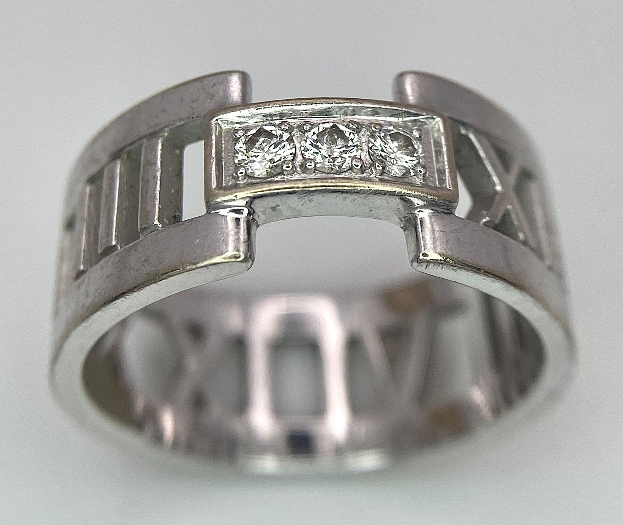 An 18K White Gold Tiffany Atlas Diamond Ring. Pierced Roman numeral decoration. Tiffany mark. Size - Image 2 of 7