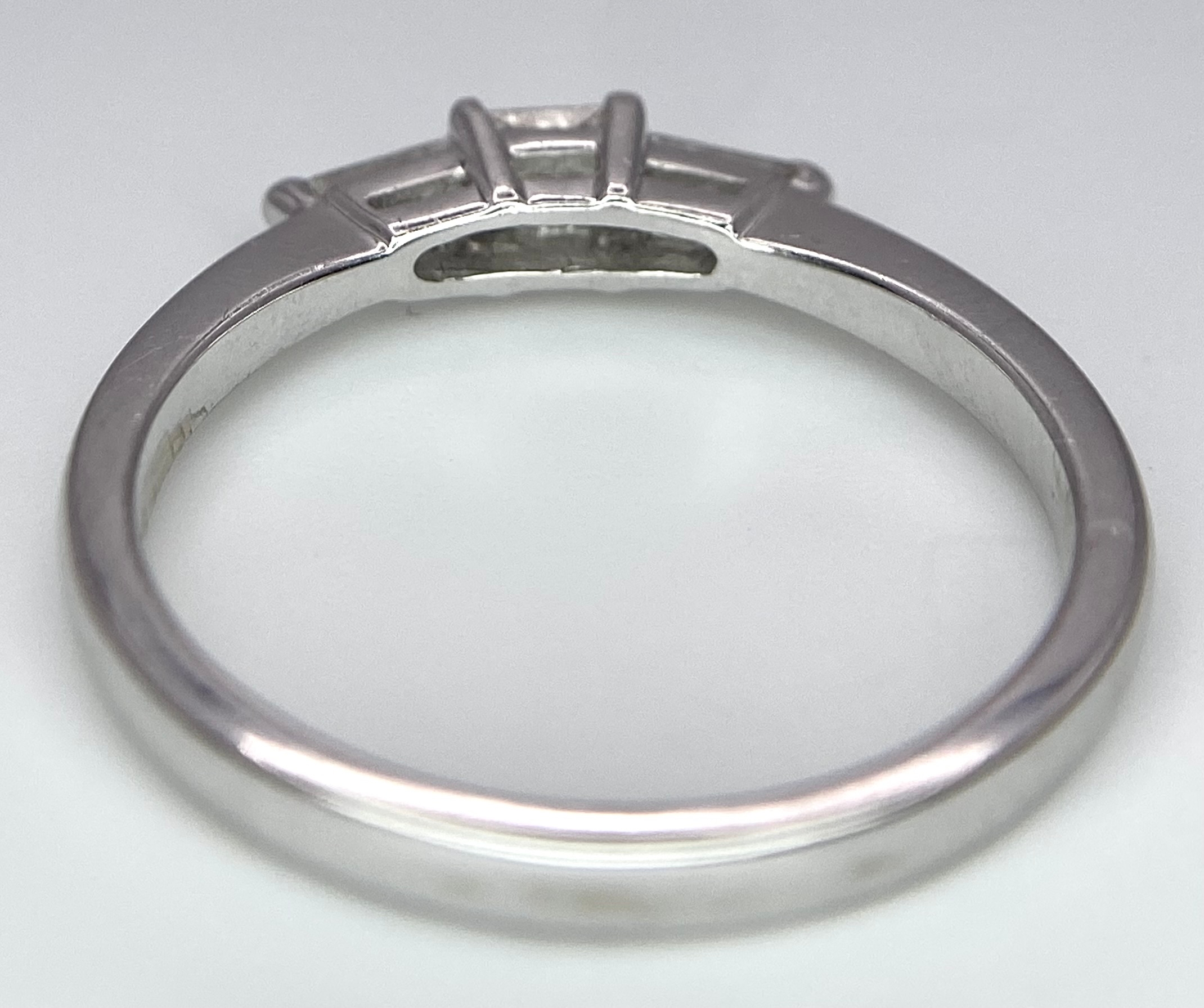 AN 18K WHITE GOLD, DIAMOND 3 STONE RING - PRINCESS CUT CENTRE WITH A TAPPERED BAGUETTE DIAMOND - Image 4 of 7