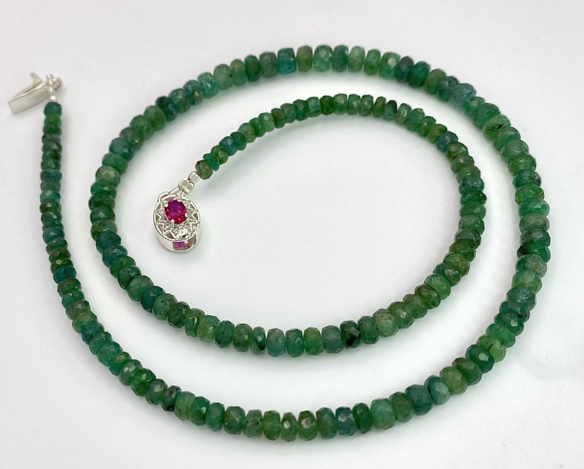 A 90ctw Single Strand Emerald Rondelle Necklace with a Ruby and 925 Silver Clasp. 42cm length.