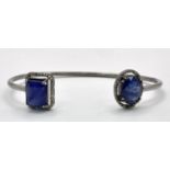 A 15ctw Blue Sapphire with 0.65ct Diamond Surround Silver Cuff Bangle. Comes with a presentation