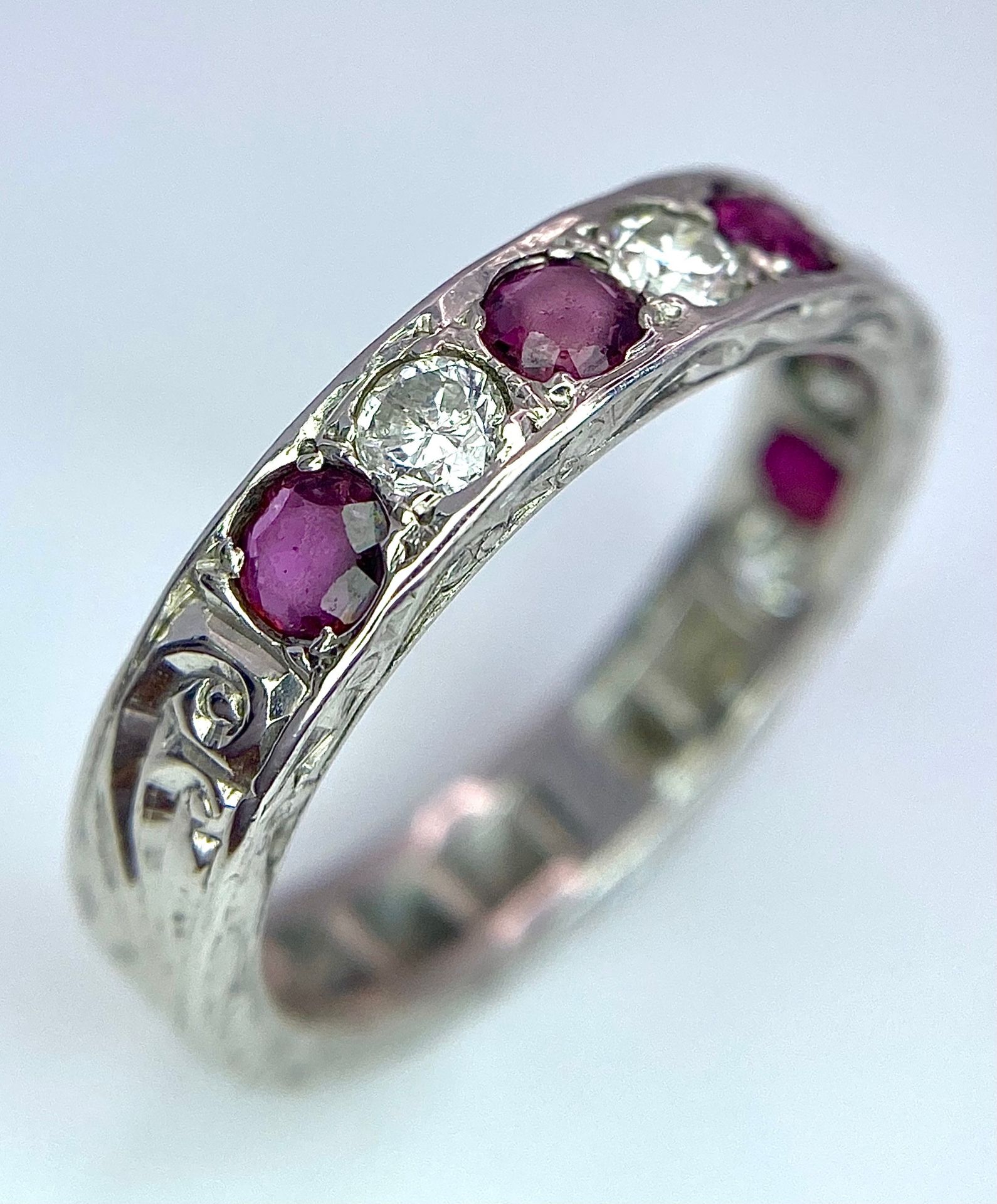 AN 18K WHITE GOLD DIAMOND & RUBY BAND RING. 0.25ctw, size L, 4.1g total weight. Ref: SC 9038