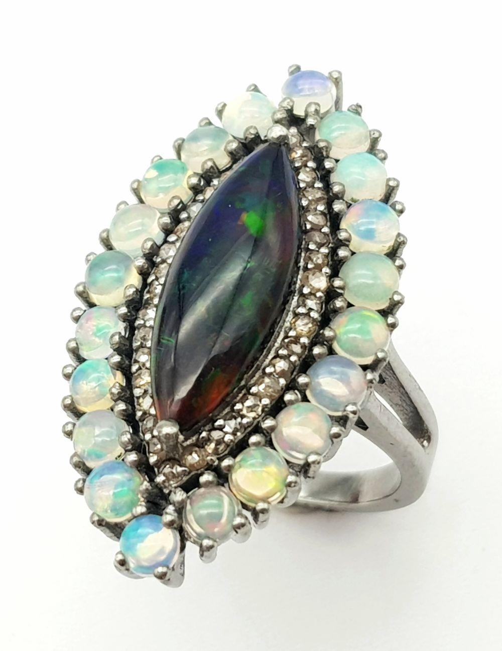 A 2ct Black Opal Marquise Shaped Ring with 1.80ctw White opal surround and .40ctw of Diamond