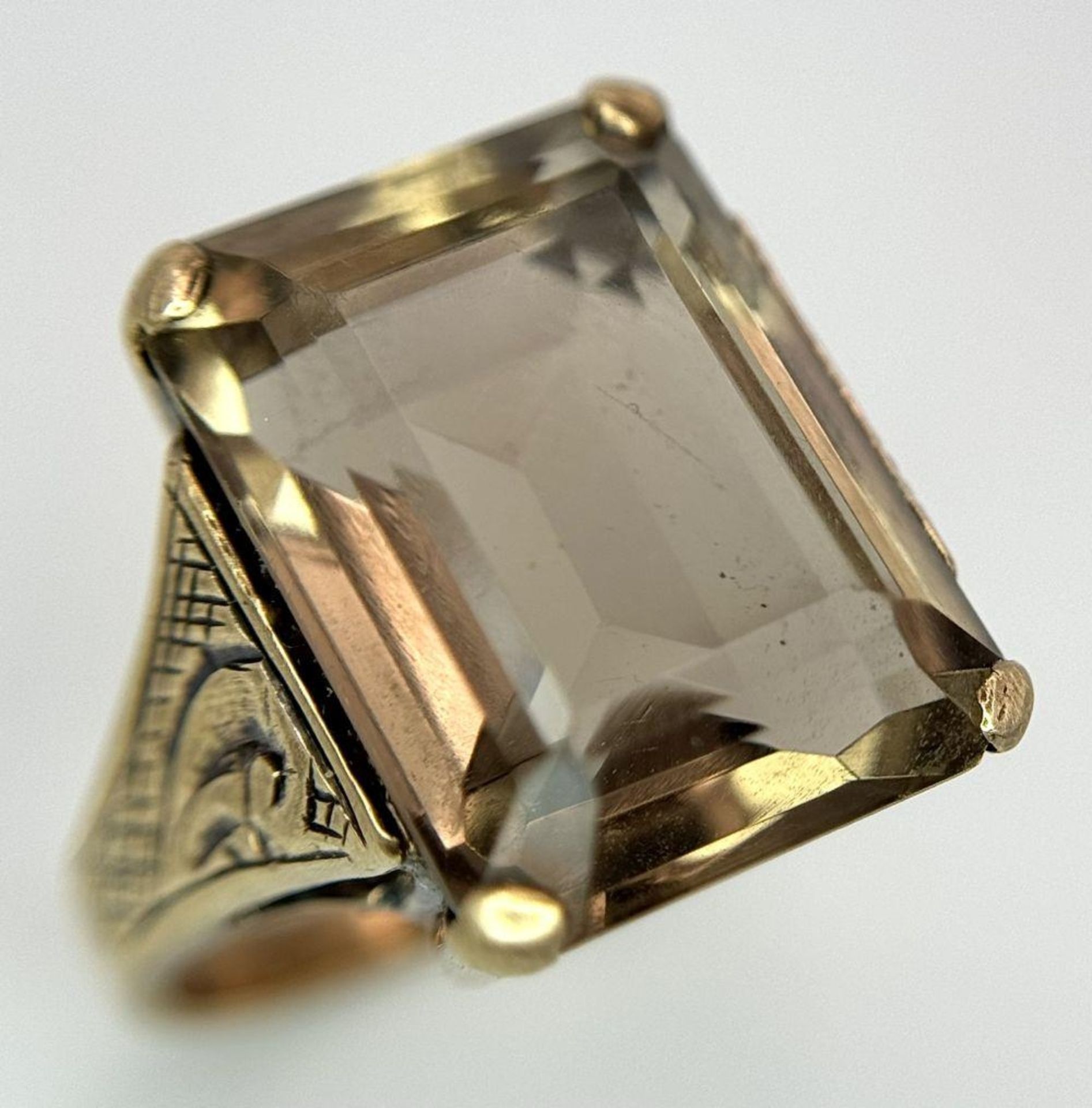 A Vintage 9K Gold Smoky Quartz Ring. Rectangular step cut on a raised decorative foundation. Size L.