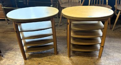 A pair of 20th century teak oval side tables, with revolving tops, 62 cm wide (2)