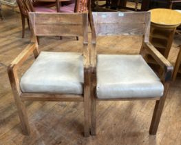 A pair of 1950s oak armchairs, with padded seats (2)