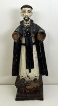 A carved and painted figure of a saint, lacking arms, on a rectangular base, 60 cm high