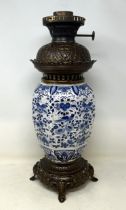 A Delft oil lamp, 46 cm high Lacking shade and chimney, unable to remove reservoir to further