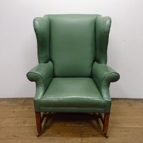 A Georgian style wingback armchair, on mahogany legs