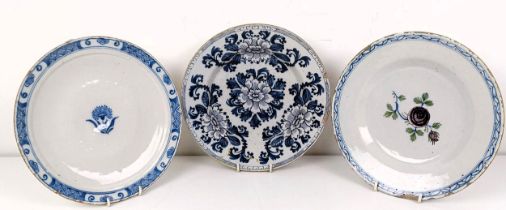 A blue and white Delft plate, decorated flowers, 23 cm diameter, and two others (3)