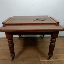 A mahogany extending dining table, with an extra leaf, on turned tapering legs and casters, the